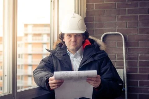Portrait of an architect builder studying layout plans of building. Soft focus Stock Photos