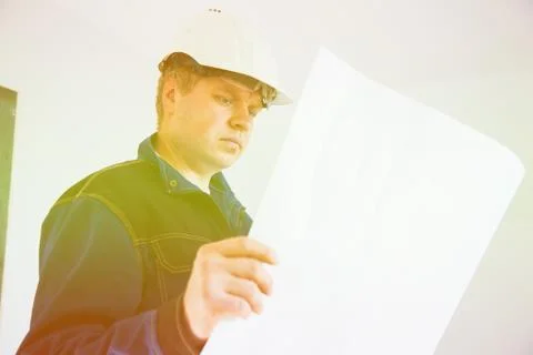 Portrait of an architect builder studying layout plan of the rooms 库存照片