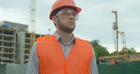 Portrait of an architect or builder in hard hat standing in front of building Stock Footage 135433075