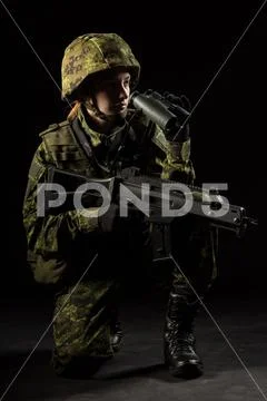 Portrait of armed woman with camouflage. Young female soldier observe with bi Stock Photos