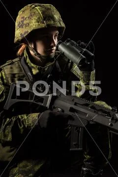 Portrait of armed woman with camouflage. Young female soldier observe with bi Stock Photos