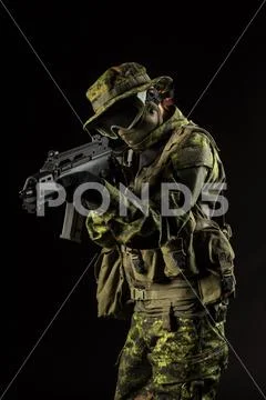 Portrait of armed woman with camouflage. Young female airsoft sniper observe Stock Photos