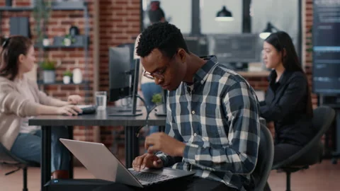 Portrait of artificial intelligence app developer sitting down typing on laptop Stock Footage 168245749