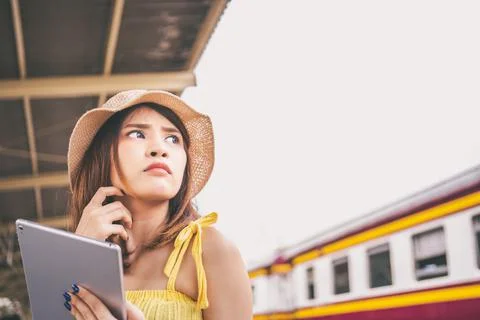 Portrait asian girl looking for travel information by tablet traveler by the  Stock Photos