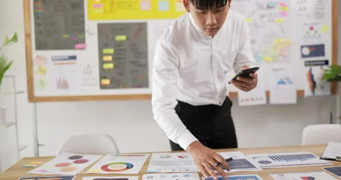 Portrait of Asian man checking to task on workplace desk while standing Stock Footage 201918858