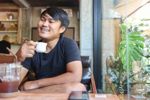 Portrait of asian man sitting in the coffee cafe with using the smartphone. T Stock Photos