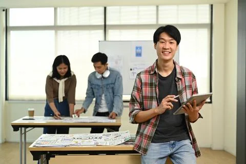 Portrait of asian man web developer standing in creative office with his Stock Photos