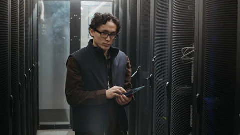 Portrait of Asian Network Engineer with Digital Tablet in Data Center Corridor Stock Footage 330546752
