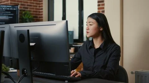 Portrait of asian programer focused on writing code sitting at desk 스톡 사진