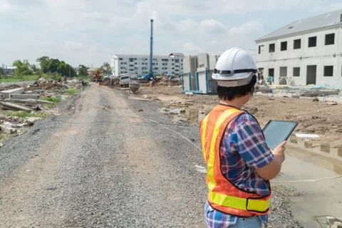 Portrait of Asian woman construction engineer worker with helmet on head usin Stock Photos