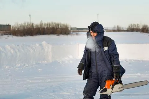 Portrait of an assembler with a chainsaw in his hands 스톡 사진