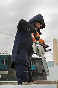 Portrait of an assembler with a chainsaw in his hands 스톡 사진