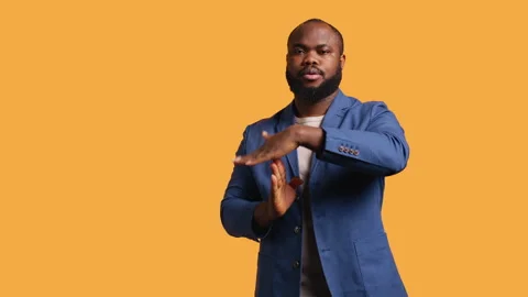 Portrait of assertive man asking for timeout, studio background Stock Footage 272535976