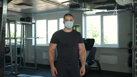 Portrait of an athletic guy with big biceps who fits in the gym to the camera Stock Footage 134576750