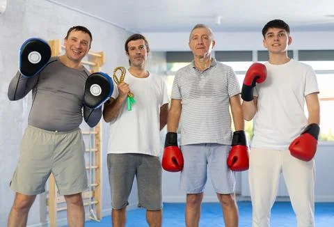 Portrait of athletic men of different ages after boxing training in gym Stock Photos