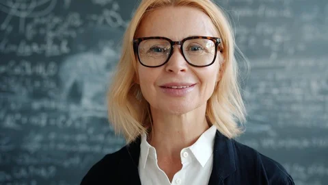 Portrait of attractive adult lady professor indoors in university class smiling Stock Footage