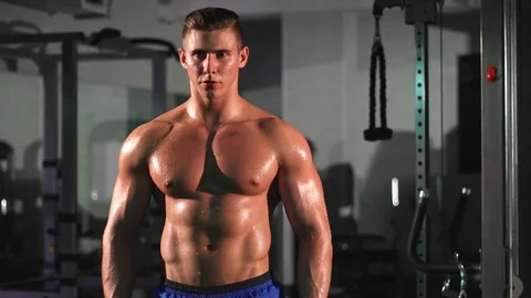 Portrait of attractive athletic man breathing heavily in fitness studio Stock Footage 77189448