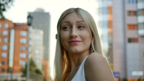 Portrait of an attractive blonde in the rays of the evening summer sun. A young Stock Footage 112944223
