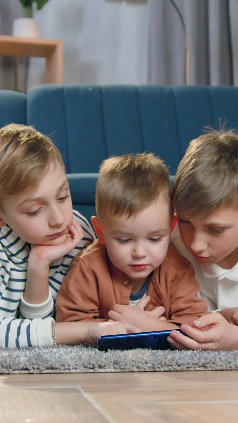 Portrait of attractive calm 2-aged,8-aged and 10-aged boys which lying on the fl Video stock 328730669