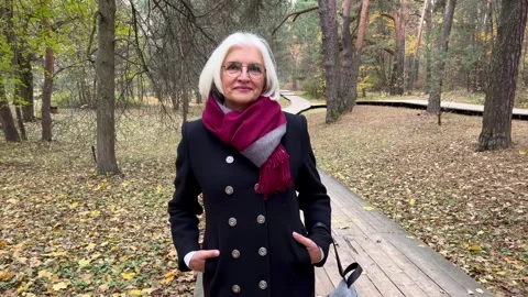 Portrait of attractive elderly 60 year old woman with gray hair and eyeglasses Stock Footage 255585130
