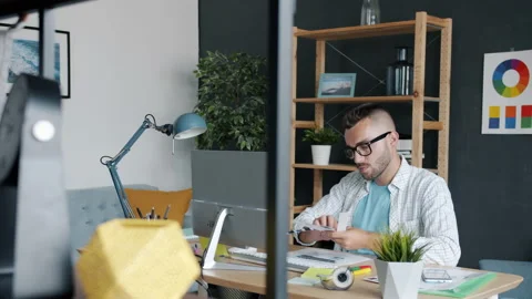 Portrait of attractive guy designer choosing colors for smartphone app interface Stock Footage 158078785