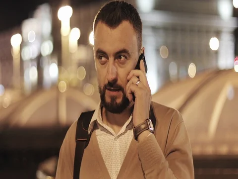 Portrait of an attractive man with a beard talking on his mobile phone. Video stock 79801344