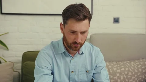 Portrait attractive man looking at camera serious worker laptop sitting on sofa Stock Footage 132541479