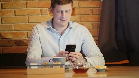 Portrait attractive man sits use phone in a cafe Stock Footage 101774113