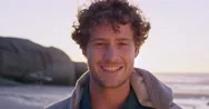 Portrait Of Attractive Man Smiling On Beach At Sunset In Slow Motion Stock Footage