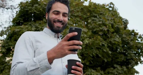 Portrait of Attractive Man Standing under the Tree and drinking hot Coffee. Stock Footage 123401283