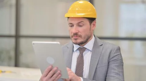 Portrait of Attractive Middle Aged Engineer using Tablet in Office Stock Photos