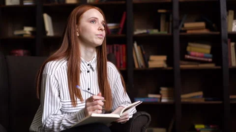 Portrait of attractive red-haired young woman journalist interviewing person in Stock Footage 136506676