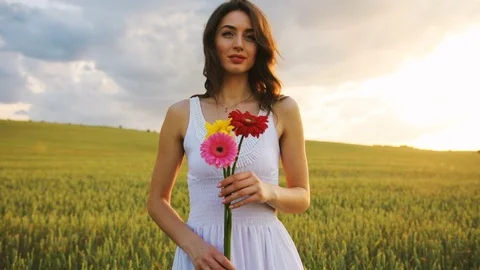 Portrait of attractive young brunette woman stending in the golden field with Stock Footage