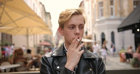 Portrait of attractive young guy standing on the street and smoking a cigarette Video stock 126575815
