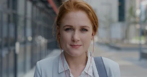 Portrait attractive young red head business woman smiling wearing earphones Stock Footage 92013160