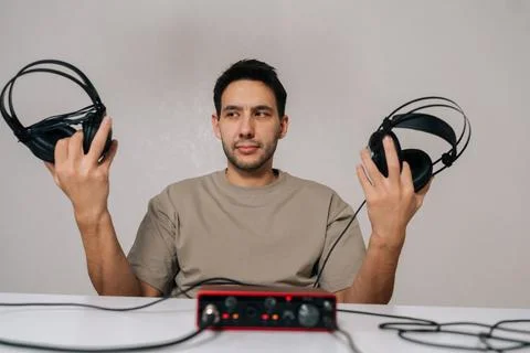 Portrait of audio engineer experiencing dilemma choosing between different Stock Photos