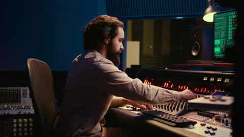 Portrait of audio technician adjusting volume levels on recordings Stock Footage 270439369