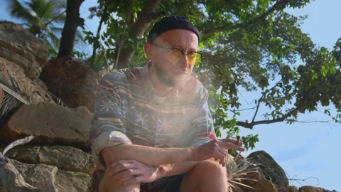 Portrait of authentic man smoking marijuana joint outdoor at sunset Stock Footage 234281386