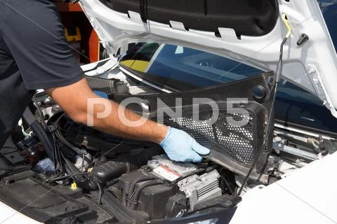 Portrait of an auto mechanic at work on a car in his garage Stock Photos