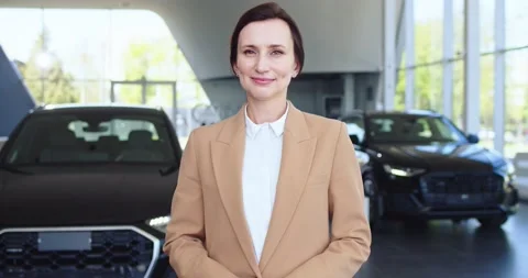Portrait of auto salon representative smiling on camera. Pleasant young lady in Stock Footage 156539337