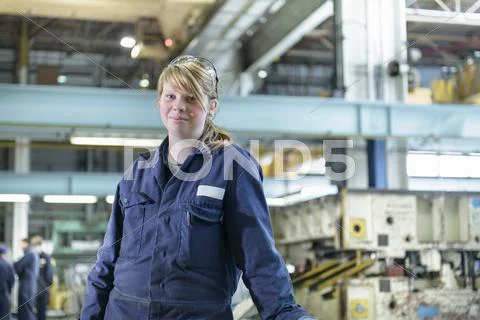 Portrait Of Automotive Apprentice Wearing Boiler Suit In Car Plant