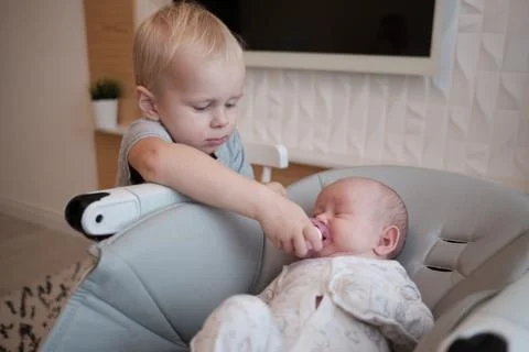 Portrait of baby boy with pacifier. His little brother sleep near him. Stock Photos