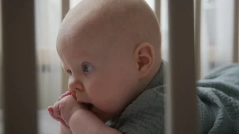 Portrait of Baby Practicing Tummy Time in Crib Looking at Camera Vídeos de archivo 346596183