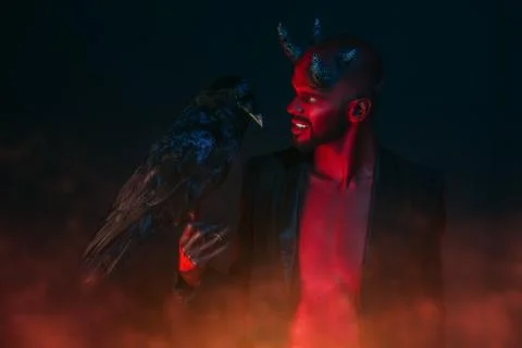 A portrait of a bad demon with a black raven. Horror movie, nightmare. Hallow Stock Photos
