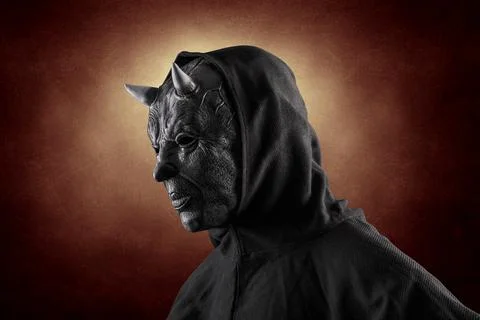 Portrait of a bad devil with horns on head over dark fiery background Stock Photos