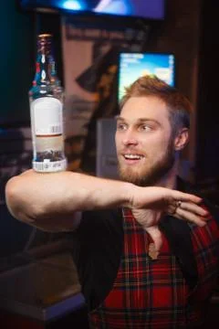 Portrait of a bartender at the bar with a bottle Stock Photos