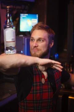 Portrait of a bartender at the bar with a bottle Stock Photos