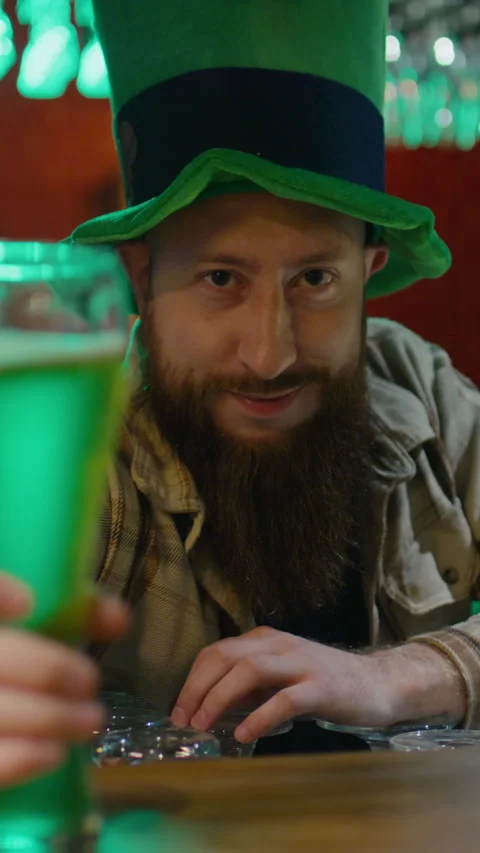 Portrait of Bearded Barman in Leprechaun Hat Serving Pint of Green Beer Stock Footage 262979761