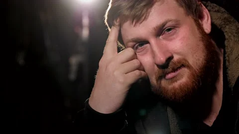 Portrait of a bearded brown-haired man who opens his eyes and looks to camera Stock Footage 222313913
