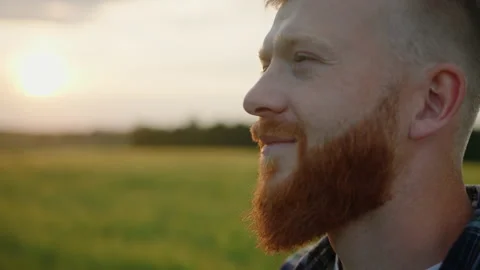 Portrait of a bearded farmer on the background of a sunset in a field Stock Footage 201484511